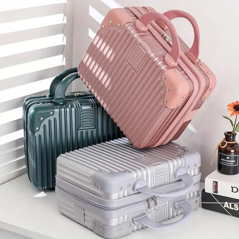 Three suitcases in pink, green, and gray on a white surface with a window in the background.