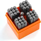 Set of metal stamps in an orange plastic holder on a white background